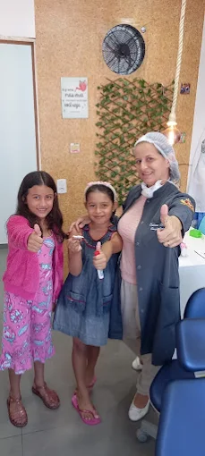 Dra. Cristiane Brelaz com pacientes sorrindo